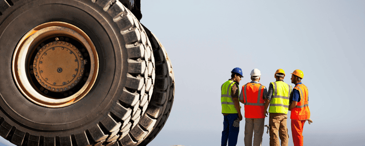 A group of construction crew standing beside truck